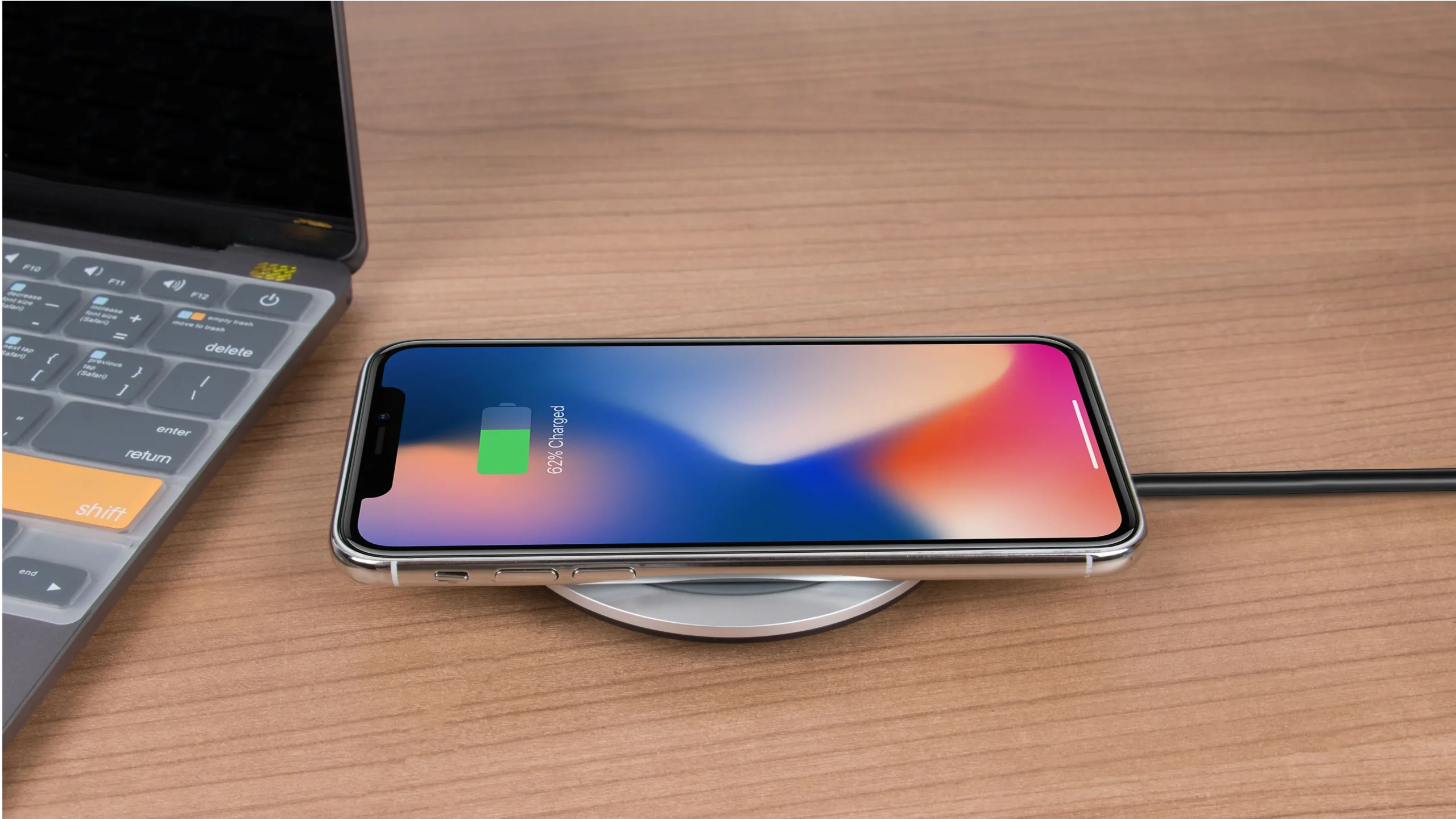 Un iPhone branché à un chargeur USB-C rapide sur un bureau.