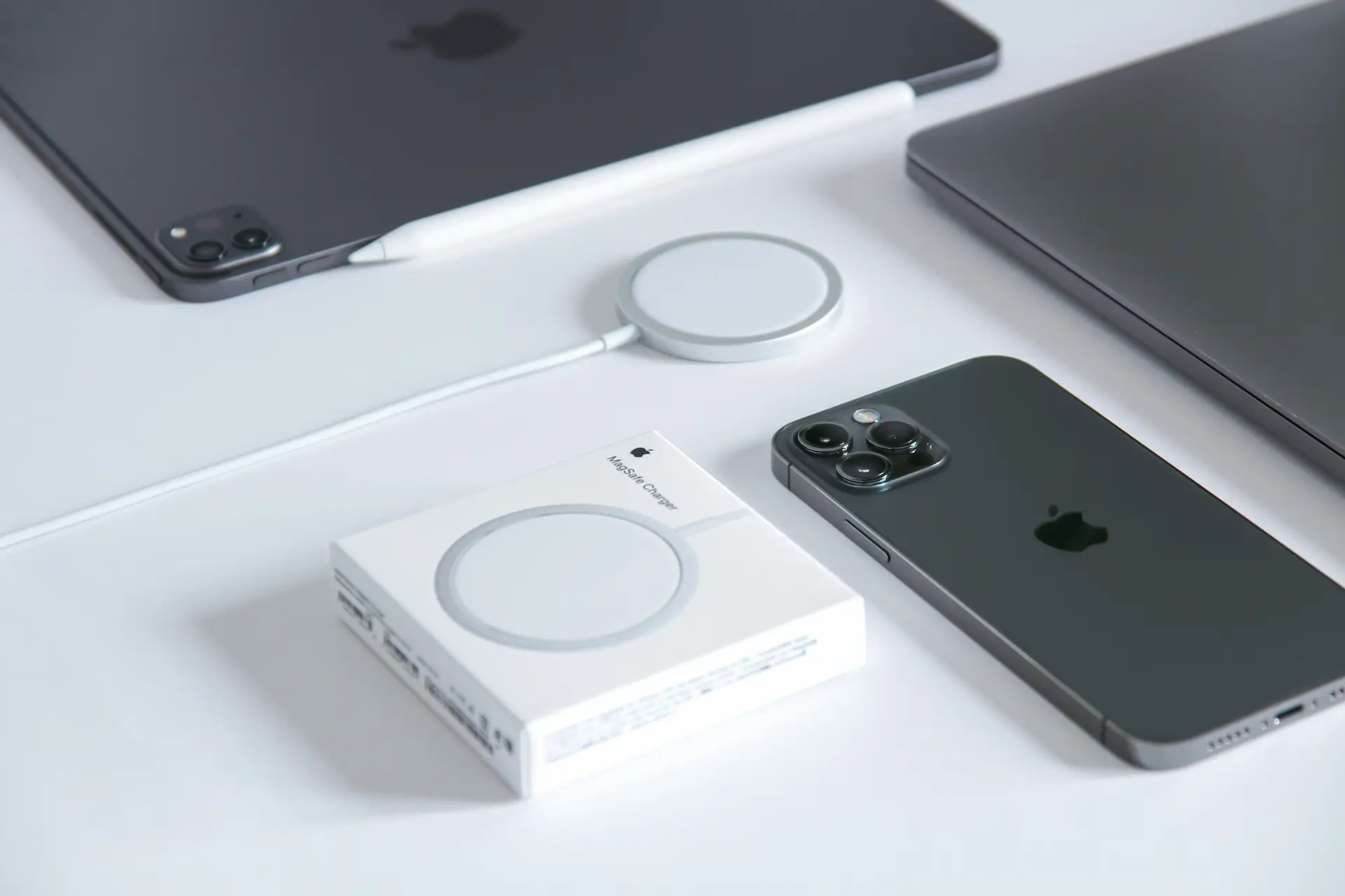 Chargeur sans fil MagSafe Qi2 posé à côté d'un smartphone sur un bureau avec son emballage à côté