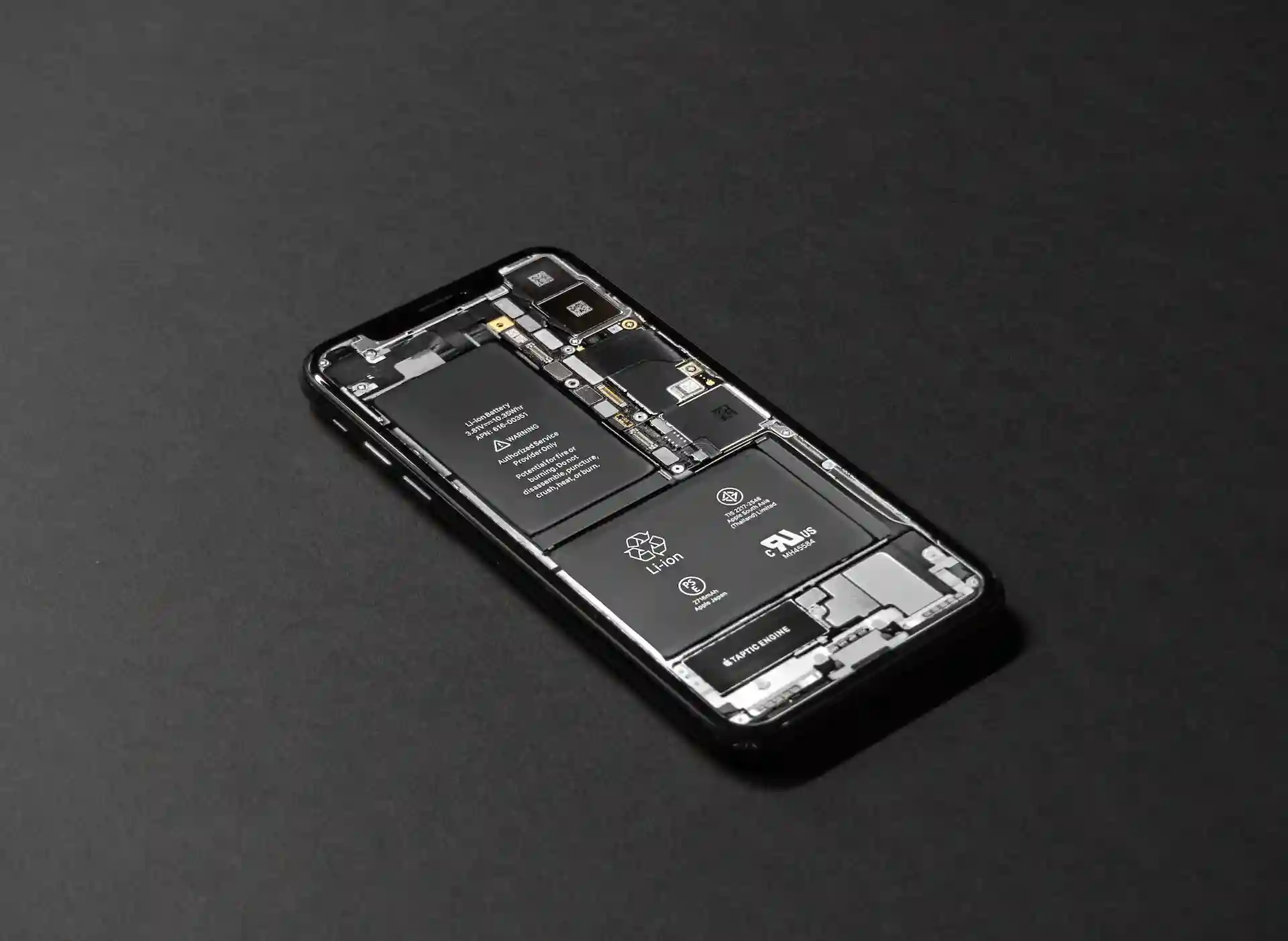 Smartphone démonté montrant une batterie amovible scellée par des vis Torx